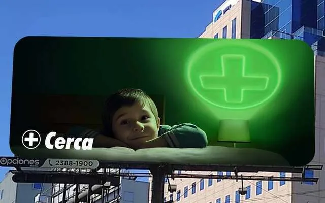 Farmacias Cruz Verde, valla Cerca: un niño recostado junto a una lámpara con la cruz verde encendida