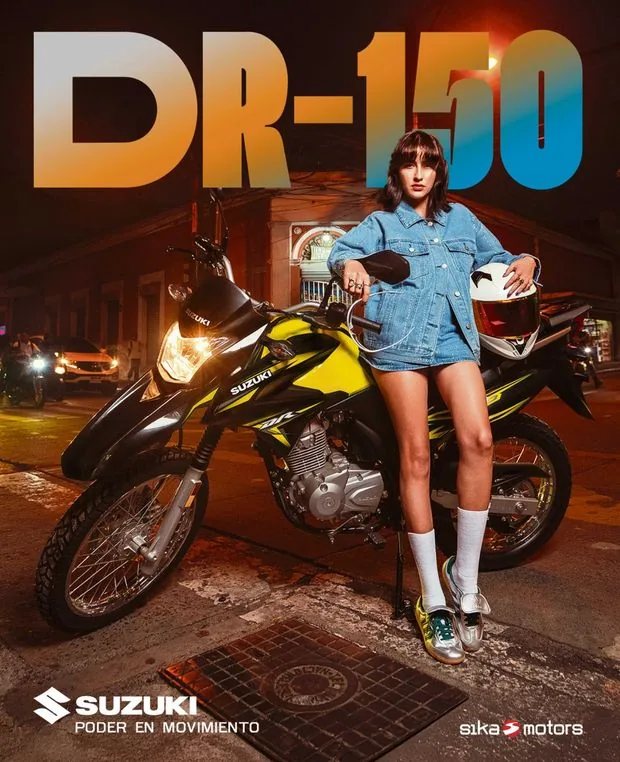Suzuki Motos, DR-150: joven recostada en una Suzuki DR-150 amarilla en una esquina de noche